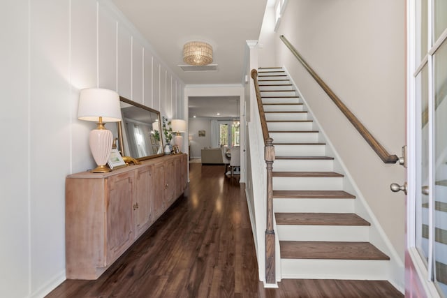 staircase featuring visible vents, baseboards, and wood finished floors