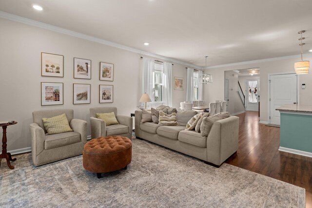 living area with dark wood-style floors, an inviting chandelier, crown molding, and baseboards