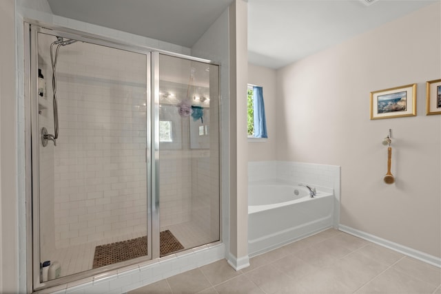 bathroom with tile patterned flooring, a shower stall, baseboards, and a garden tub