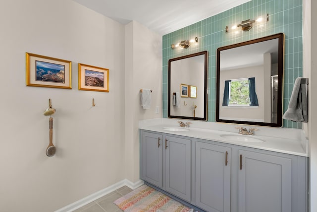 full bathroom featuring a sink, baseboards, double vanity, and tile patterned floors