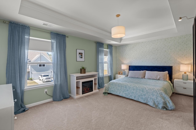 carpeted bedroom with a tray ceiling, multiple windows, and visible vents