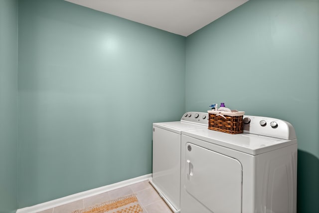 laundry room with light tile patterned floors, baseboards, separate washer and dryer, and laundry area