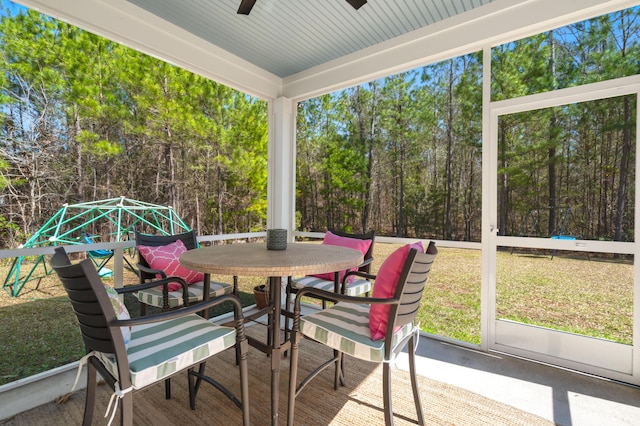 sunroom / solarium featuring a ceiling fan