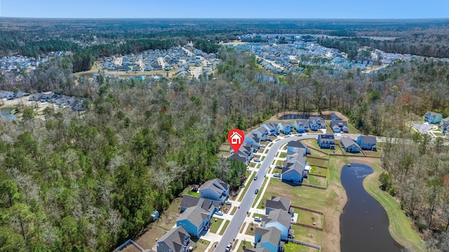 birds eye view of property featuring a water view, a wooded view, and a residential view