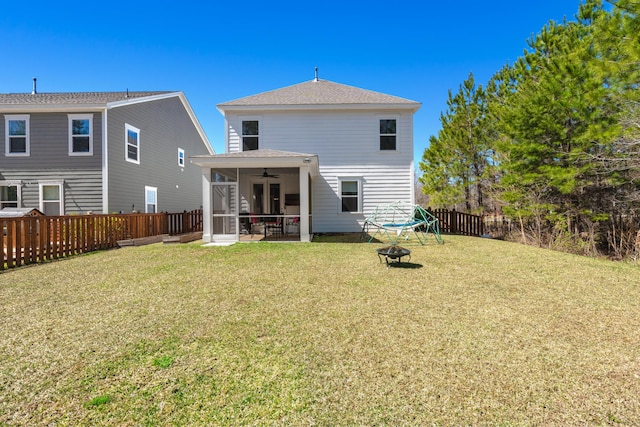 back of property with roof with shingles, a lawn, a fenced backyard, a sunroom, and a ceiling fan