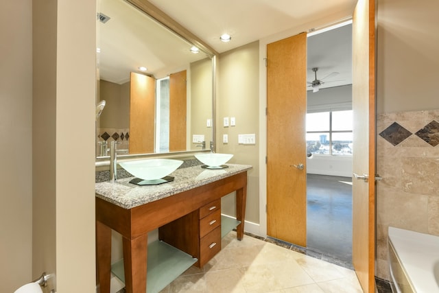 bathroom with tile patterned floors, ceiling fan, a tub to relax in, and vanity