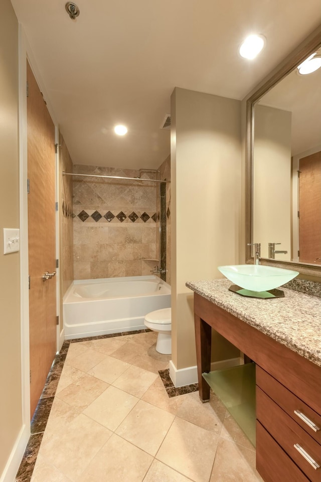 full bathroom featuring tile patterned floors, vanity, toilet, and tiled shower / bath