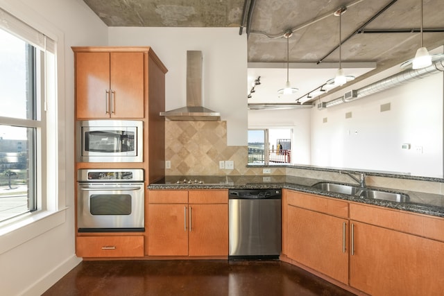 kitchen featuring dark stone counters, sink, wall chimney exhaust hood, decorative backsplash, and stainless steel appliances