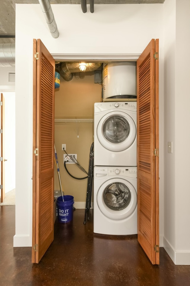 clothes washing area with stacked washing maching and dryer