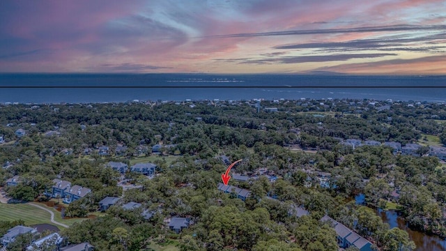 aerial view at dusk featuring a water view