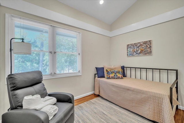 bedroom featuring wood-type flooring, multiple windows, and vaulted ceiling