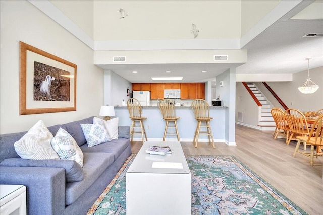 living room featuring a high ceiling and light hardwood / wood-style flooring