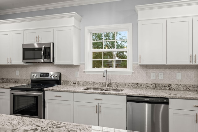 kitchen featuring backsplash, crown molding, stainless steel appliances, and a sink