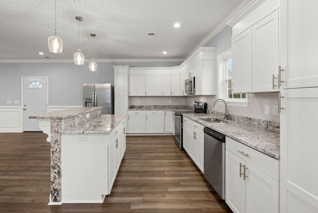 kitchen with a center island, crown molding, stainless steel appliances, white cabinetry, and a sink