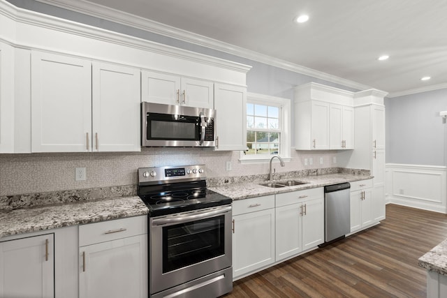 kitchen with crown molding, appliances with stainless steel finishes, dark wood-type flooring, white cabinetry, and a sink