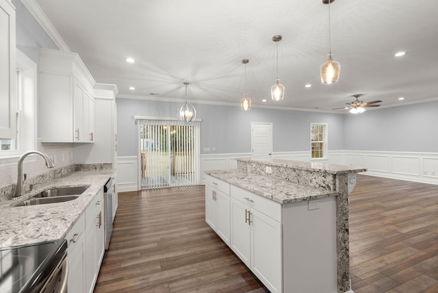 kitchen featuring dark wood-style flooring, a kitchen island, a sink, white cabinets, and appliances with stainless steel finishes