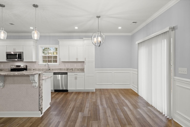 kitchen featuring appliances with stainless steel finishes, wood finished floors, white cabinetry, and light stone countertops