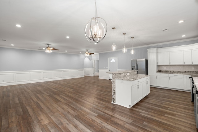 kitchen featuring dark wood-type flooring, open floor plan, stainless steel fridge, and a kitchen island