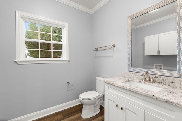 bathroom with toilet, wood finished floors, vanity, baseboards, and crown molding