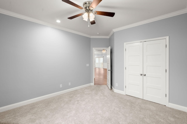 unfurnished bedroom featuring baseboards, ornamental molding, a closet, and light colored carpet