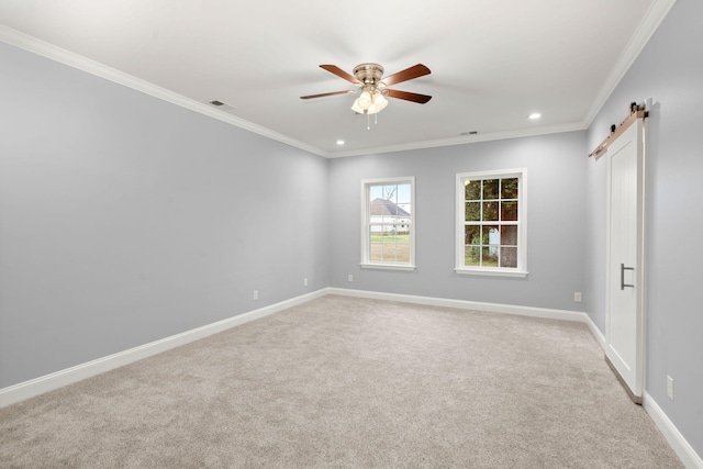 unfurnished room featuring a ceiling fan, a barn door, baseboards, and crown molding