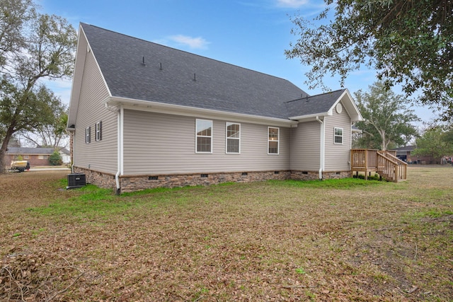 rear view of house featuring crawl space, roof with shingles, a lawn, and central AC unit