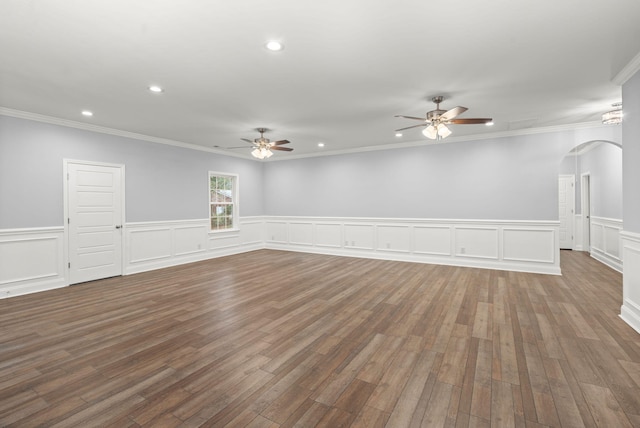 empty room with arched walkways, crown molding, recessed lighting, a ceiling fan, and wood finished floors