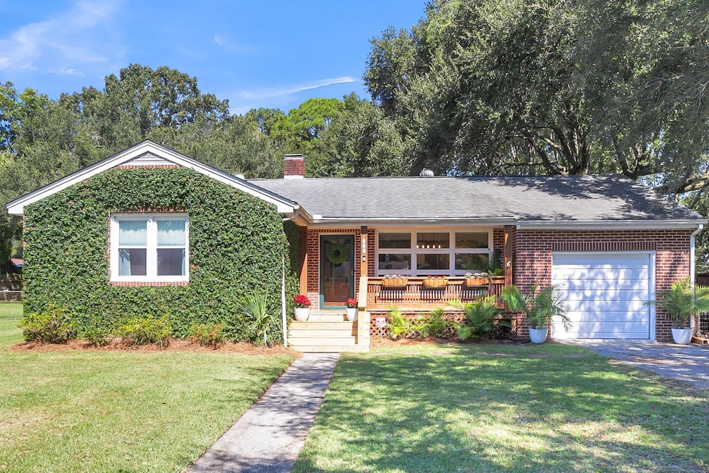 ranch-style home featuring a front yard, a garage, and a porch