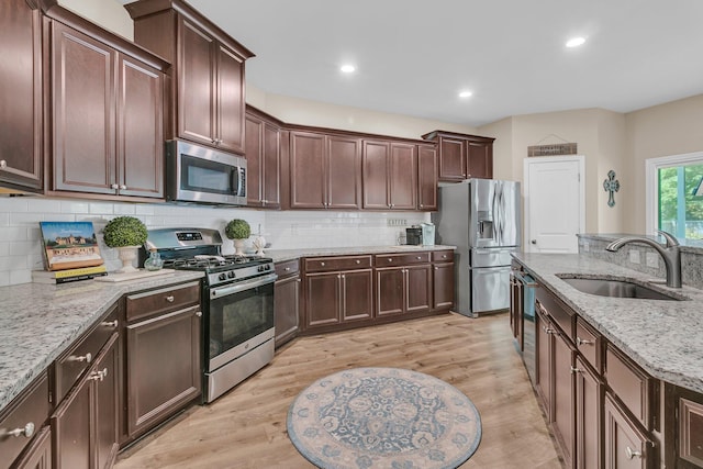 9829 English Elm St, Ladson, SC 29456 - kitchen with appliances with stainless steel finishes, a sink, light wood-type flooring, tasteful backsplash, and recessed lighting