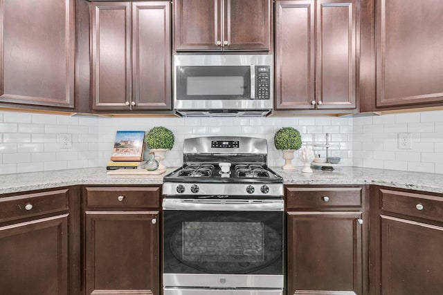 9829 English Elm St, Ladson, SC 29456 - kitchen featuring stainless steel appliances, decorative backsplash, dark brown cabinets, and light stone countertops