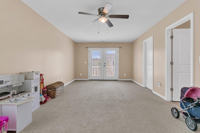 9829 English Elm St, Ladson, SC 29456 - unfurnished living room with french doors, carpet floors, ceiling fan, baseboards, and a sink