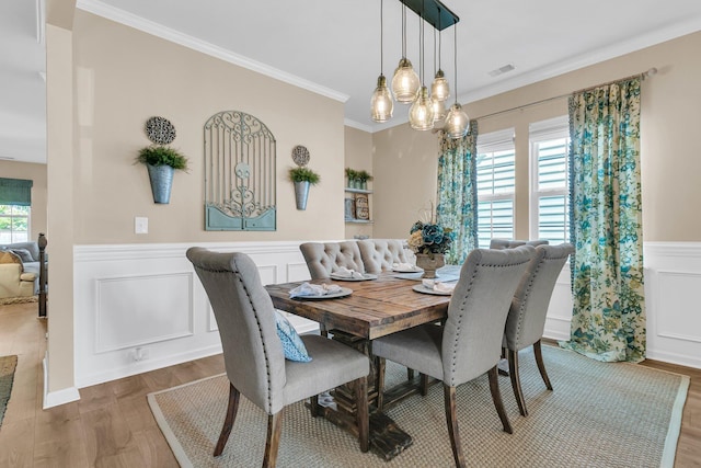 9829 English Elm St, Ladson, SC 29456 - dining space with a wainscoted wall, ornamental molding, wood finished floors, a decorative wall, and a chandelier