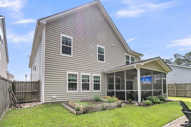 9829 English Elm St, Ladson, SC 29456 - rear view of house with a vegetable garden and a sunroom