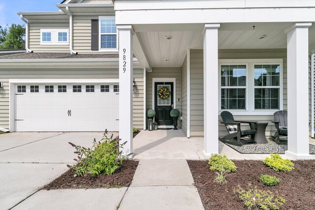 9829 English Elm St, Ladson, SC 29456 - property entrance featuring a garage, covered porch, and driveway