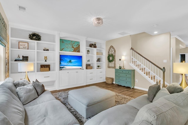 9829 English Elm St, Ladson, SC 29456 - living room with stairway, wood finished floors, built in shelves, baseboards, and crown molding