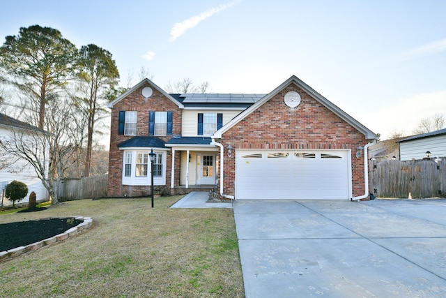 traditional-style house with solar panels, driveway, an attached garage, and fence