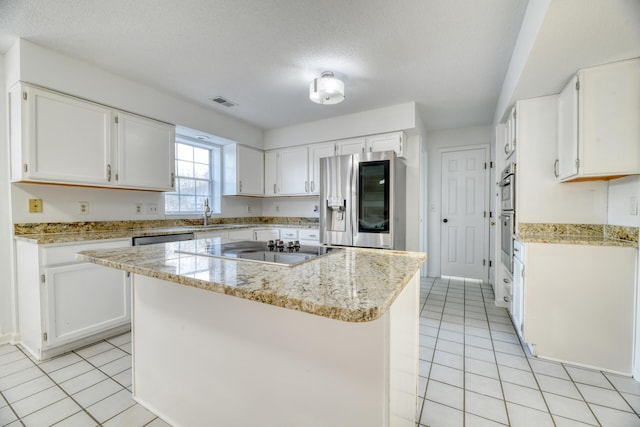 kitchen featuring light tile patterned floors, stainless steel appliances, and white cabinetry