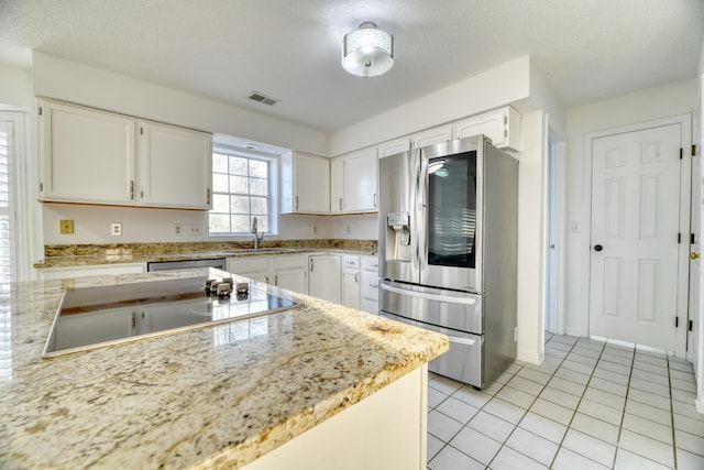 kitchen featuring stainless steel appliances, white cabinets, and visible vents