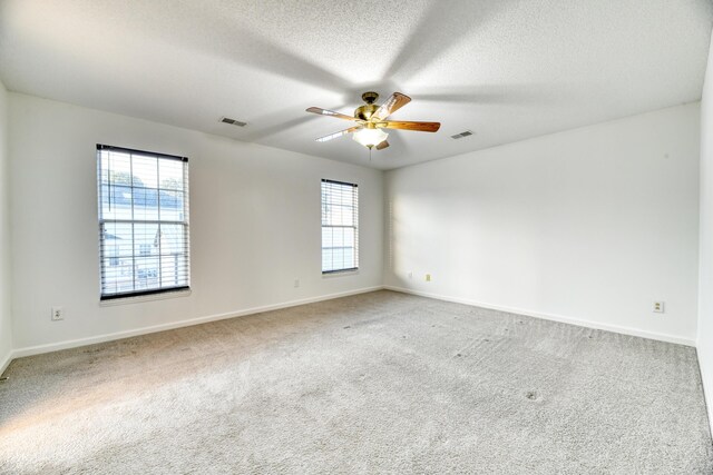 spare room with a wealth of natural light, carpet, and visible vents