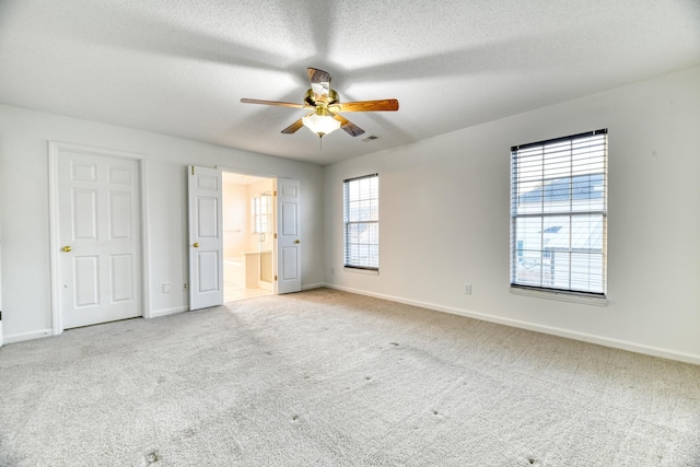 unfurnished bedroom with a textured ceiling, carpet floors, and baseboards