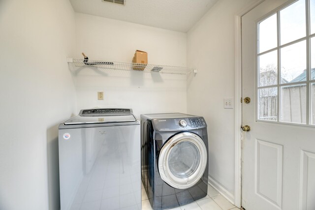 washroom featuring laundry area, visible vents, baseboards, and separate washer and dryer