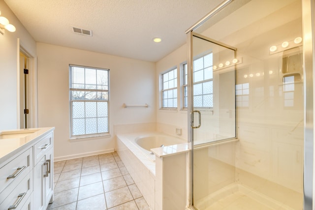 full bathroom featuring a textured ceiling, a garden tub, vanity, visible vents, and a shower stall