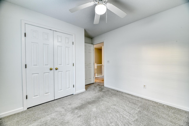 unfurnished bedroom featuring carpet floors, a ceiling fan, baseboards, and a closet