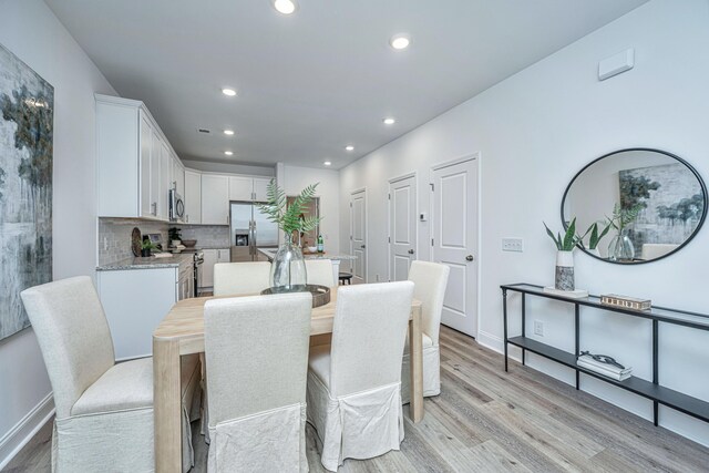 dining room with light wood-style flooring, baseboards, and recessed lighting