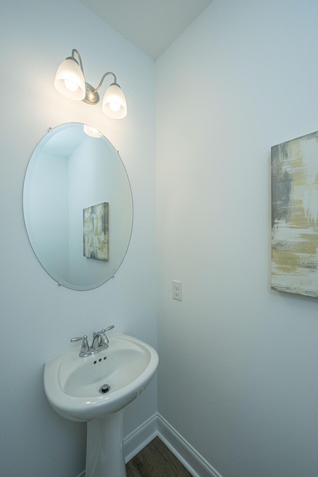 bathroom with baseboards and wood finished floors