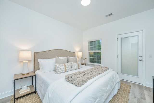 bedroom with visible vents, baseboards, and wood finished floors