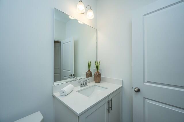 half bathroom with toilet and vanity