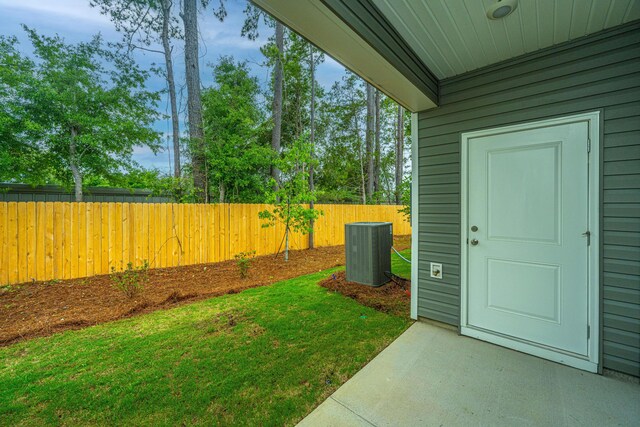 view of yard featuring central air condition unit and fence