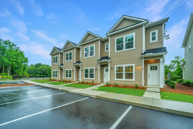 multi unit property featuring a tennis court, uncovered parking, and fence