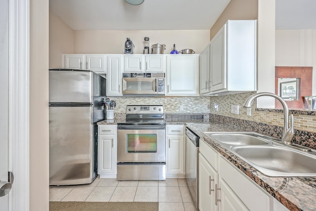 kitchen featuring white cabinetry, sink, backsplash, light tile patterned floors, and appliances with stainless steel finishes